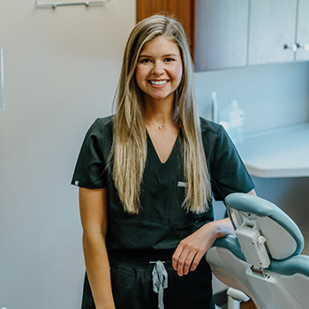 Dr. Kathleen Bartunek smiling in her dental scrubs